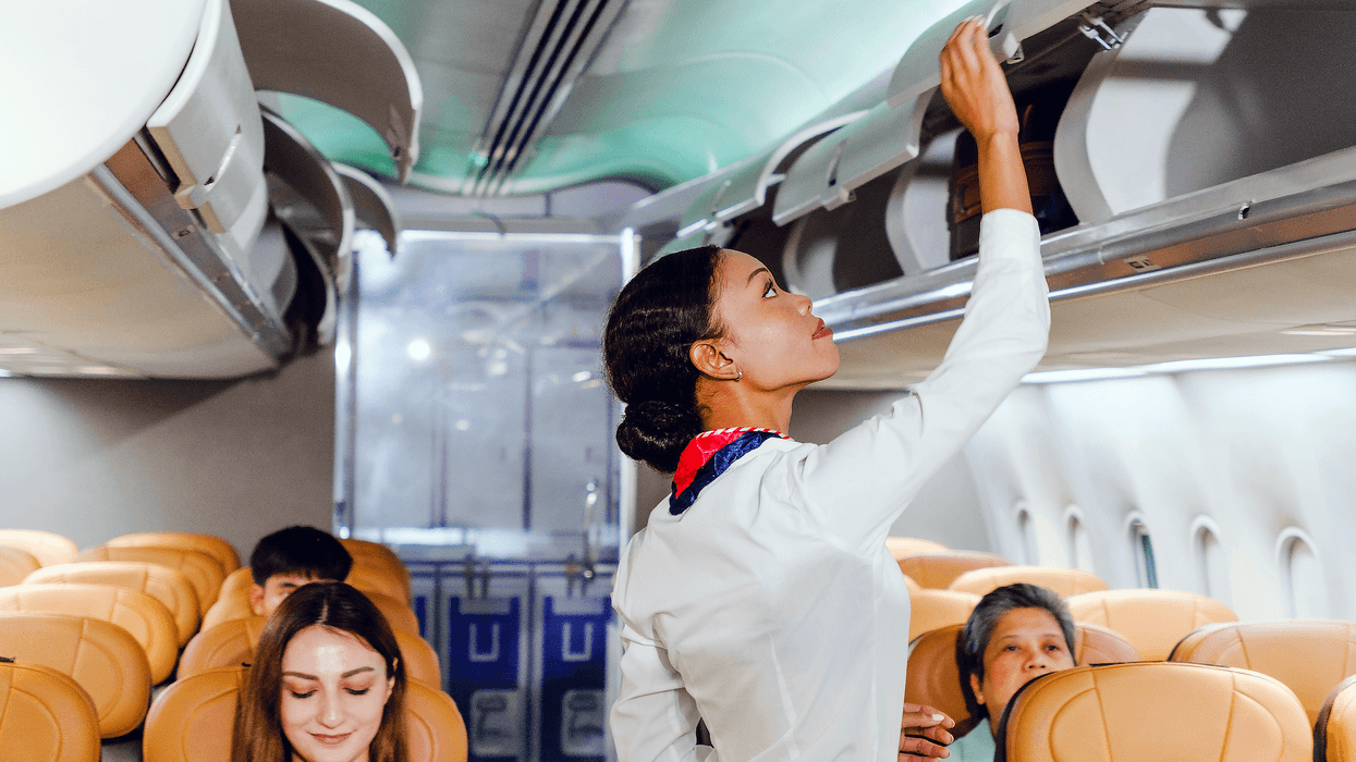 Une agente de bord dans un avion avec des passagers.