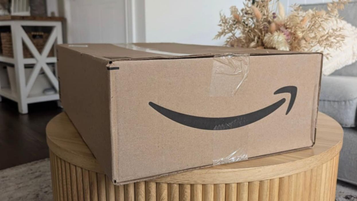 Une boîte de livraison Amazon déposée sur une table de salon.