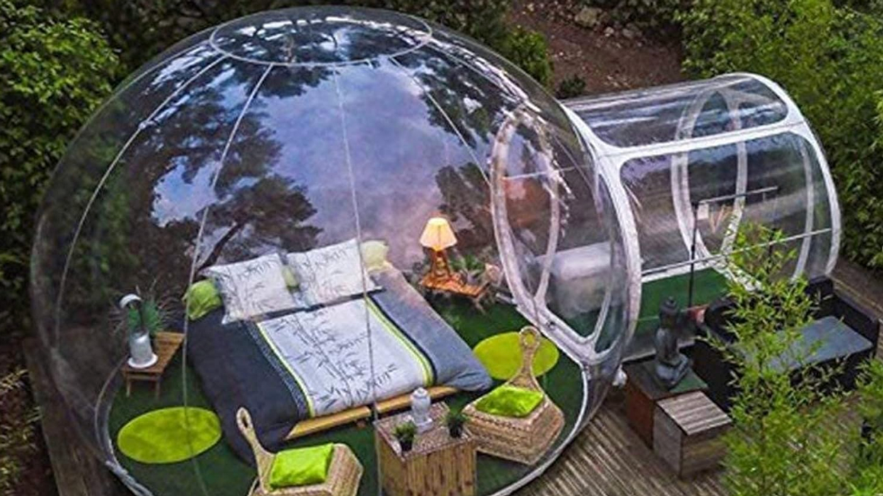 Une bulle gonflable sur une terrasse avec des meubles à l'intérieur.