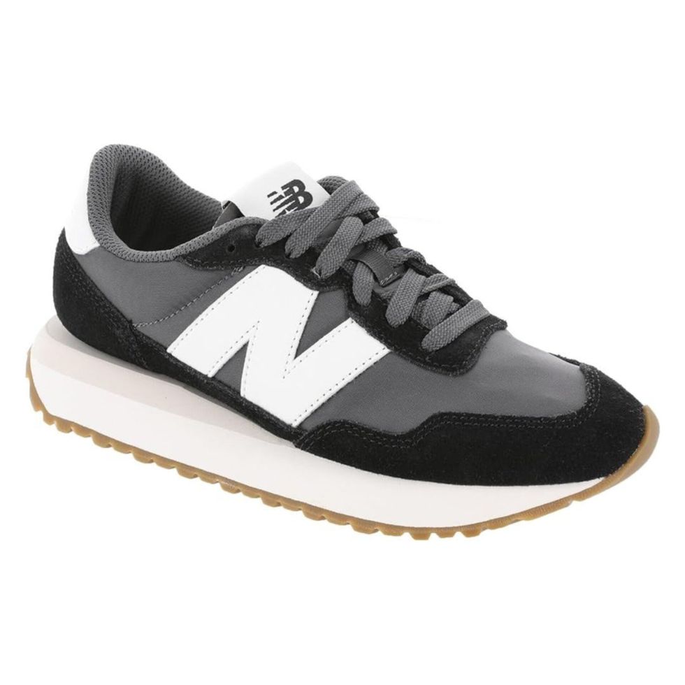 Une chaussure de sport noire et blanche de marque New Balance sur fond blanc.