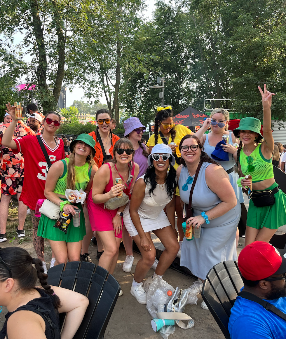 Une gang de festivali\u00e8res habill\u00e9es aux couleurs de l'arc-en-ciel.