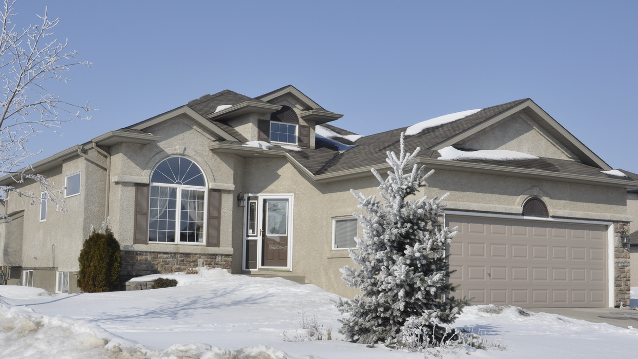 Une grande maison au Québec dans un paysage hivernal.