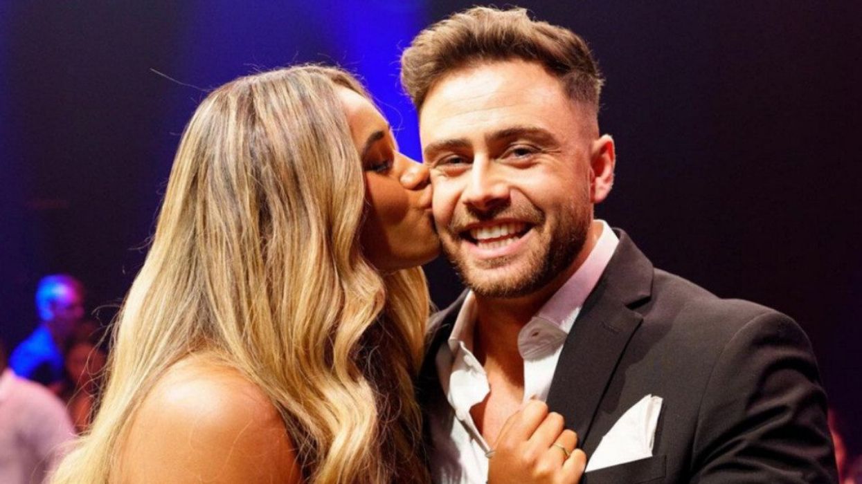 Une jeune femme donnant un baiser sur la joue d'une homme.