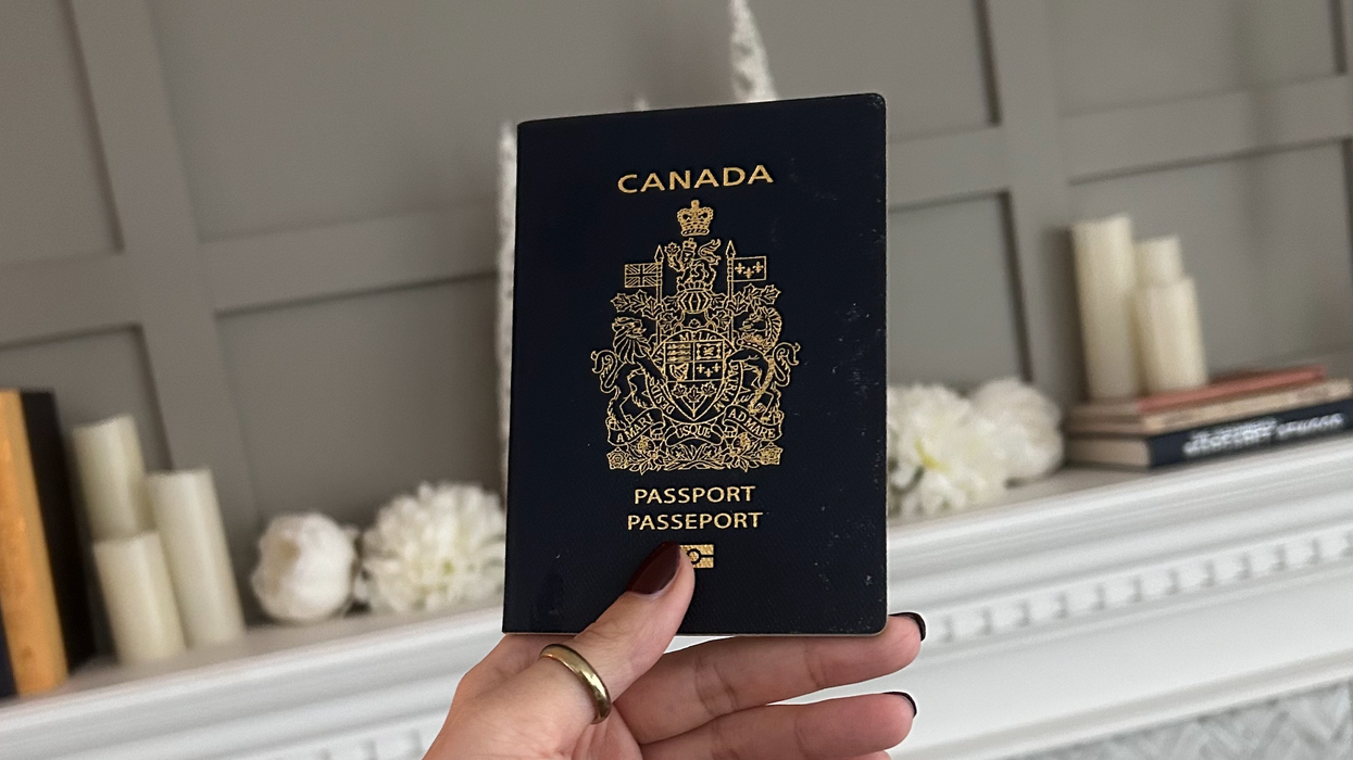 Une main tenant un passeport canadien. 