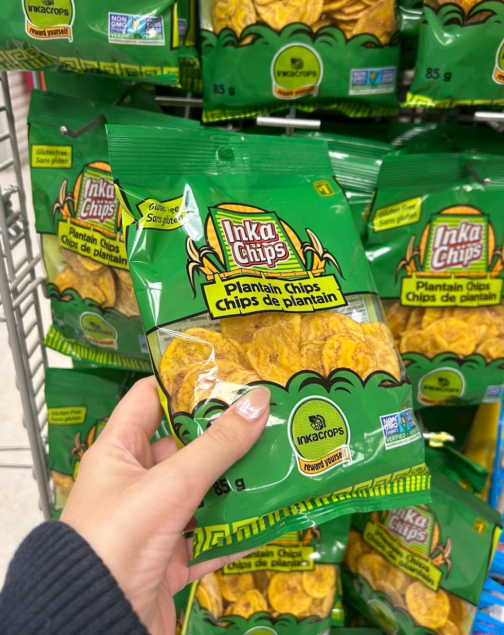 Une main tenant un sac de chips de plantain au Dollarama.