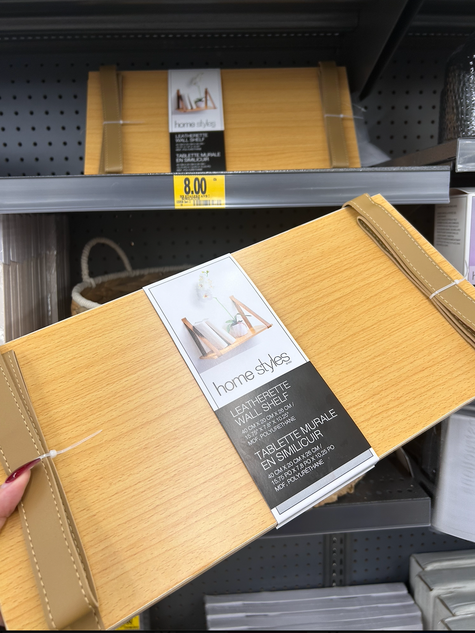 Une main tenant une tablette murale avec languettes en similicuir dans un Tigre G\u00e9ant.