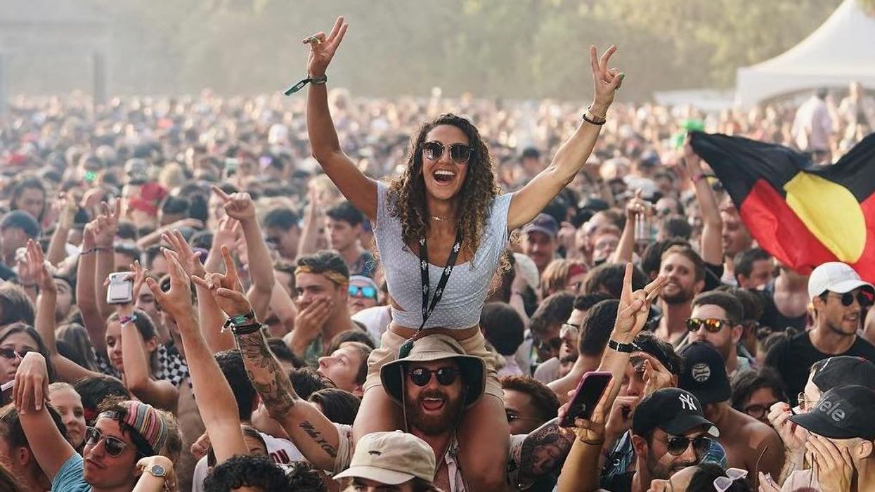 Une personne assise sur les épaules d'une autre, dans la foule d'un festival à Mnontréal.
