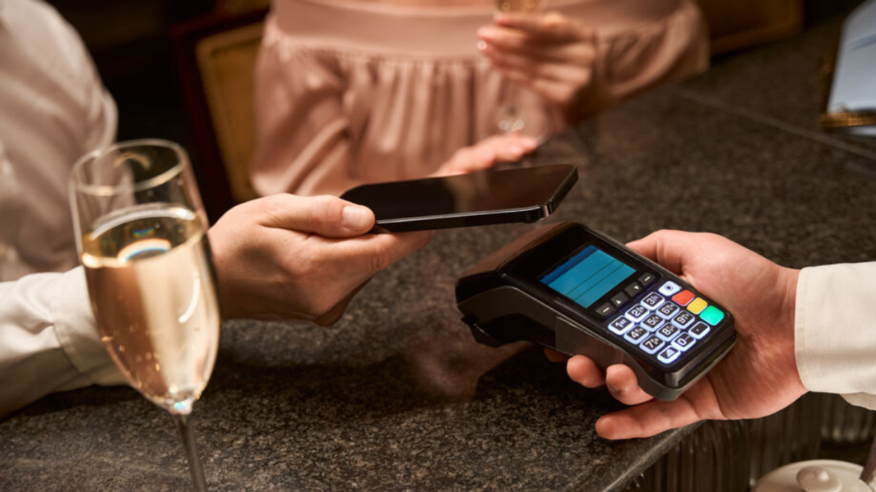 Une personne qui paye à un terminal bancaire.