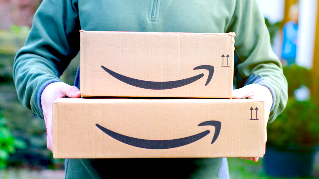 Une personne qui tient des boîtes Amazon.