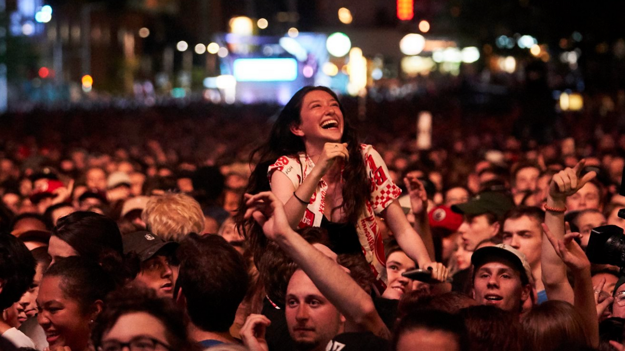 Une personne surélevée au centre de la foule du festival Francos de Montréal.
