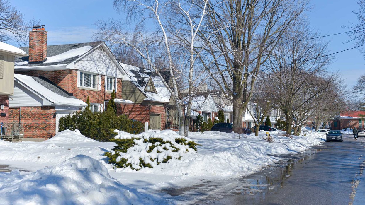 Une rues enneigées et des maisons.
