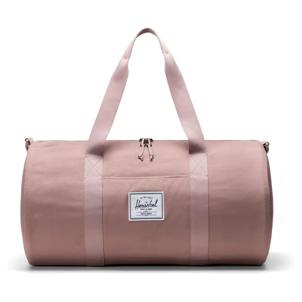 Une sac de transport rose de marque Herschel sur fond blanc.
