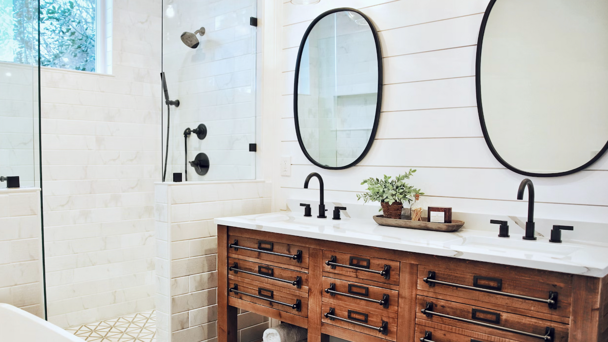 Une salle de bain blanche avec une vanité double en bois.