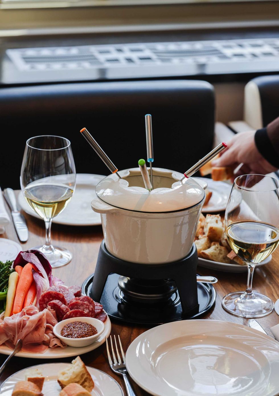 Une tabl\u00e9e avec de la fondue au fromage, des l\u00e9gumes et du pain cro\u00fbt\u00e9 au Restaurant \u00cele de France.