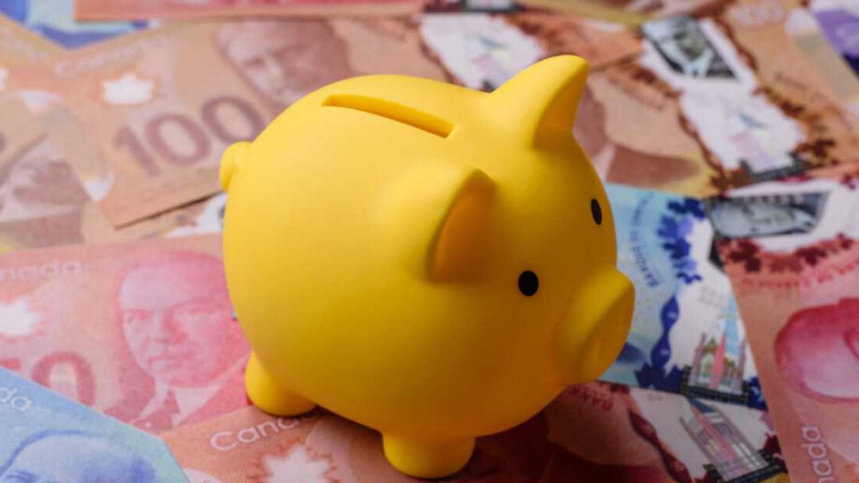 Une tirelire posée sur de l'argent canadien.
