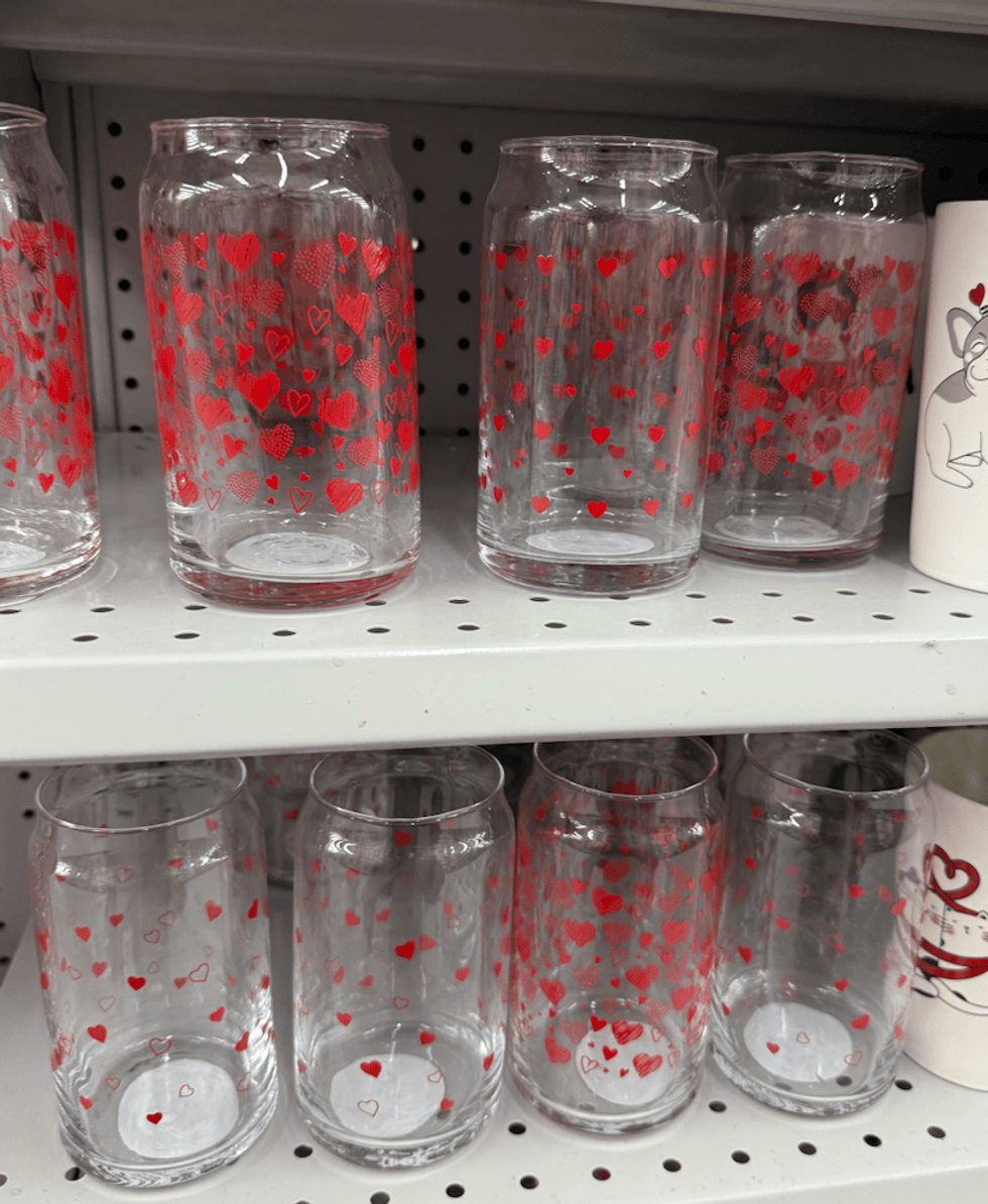 Verres en verre transparents orn\u00e9s de petits c\u0153urs rouges, align\u00e9s sur une tablette du Dollarama.