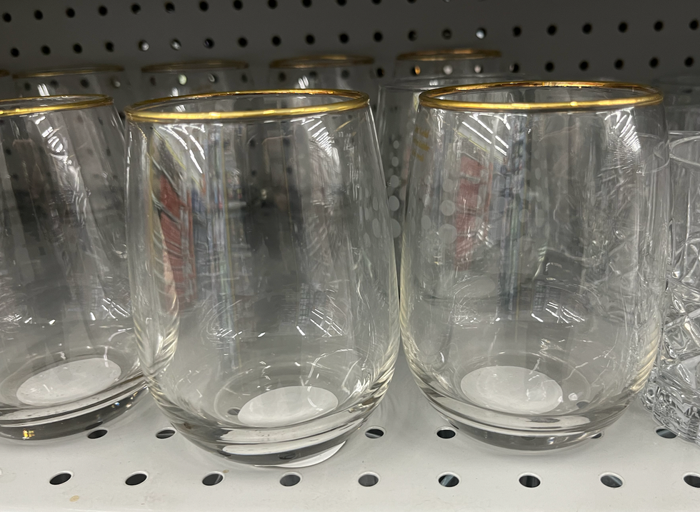 Verres \u00e0 vin avec un d\u00e9tail dor\u00e9 sur les tablettes du Dollarama.