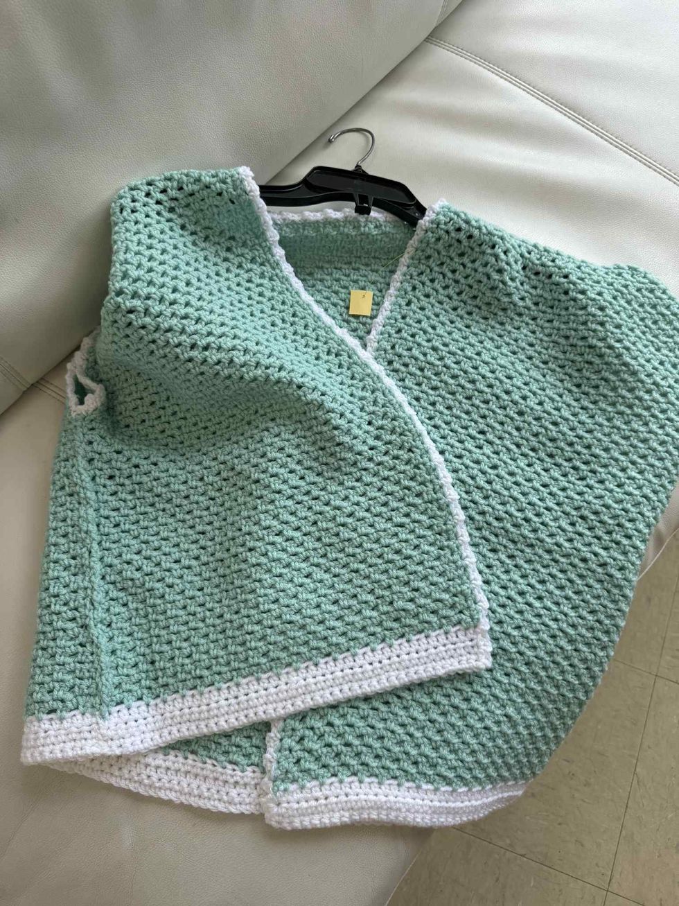 Veste turquoise et blanche crochet\u00e9e \u00e0 la main dans la section liquidation pour adultes de la friperie Au Grenier Populaire.