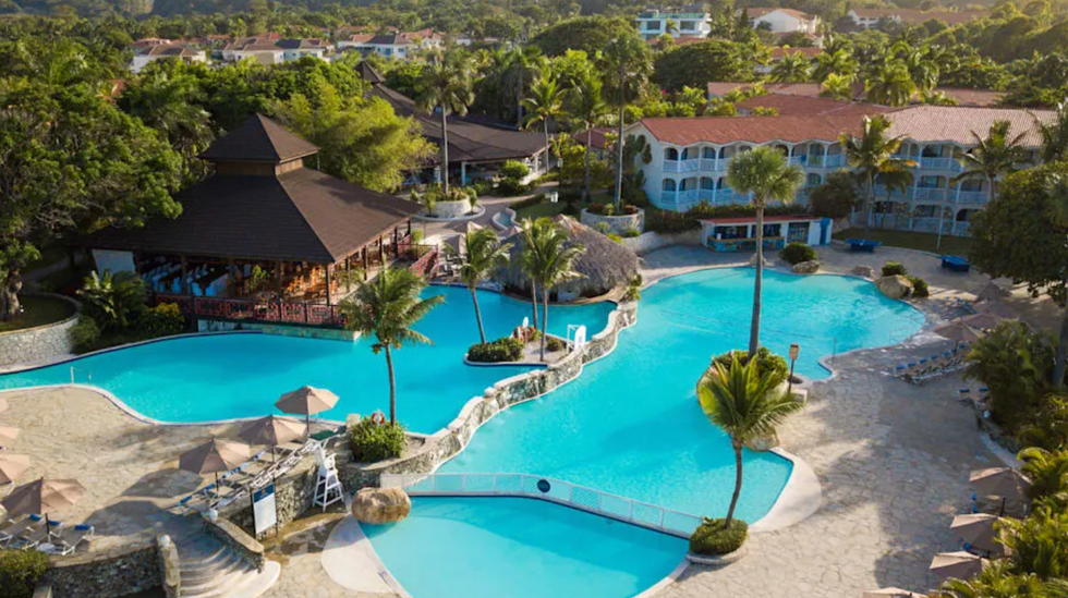 Vue a\u00e9rienne du Lifestyle Tropical Beach Resort and Spa avec ses piscines sinueuses entour\u00e9es de palmiers.
