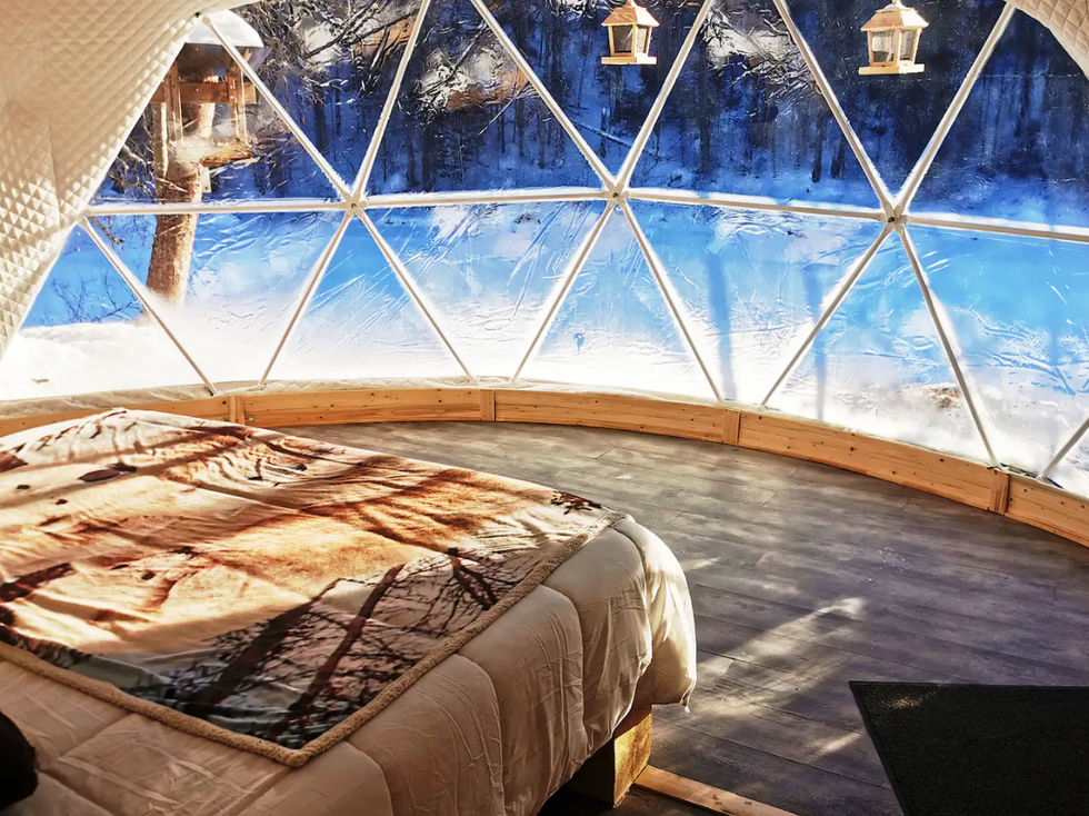 vue sur l'ext\u00e9rieur \u00e0 partir d'un d\u00f4me transparent muni d'un lit.